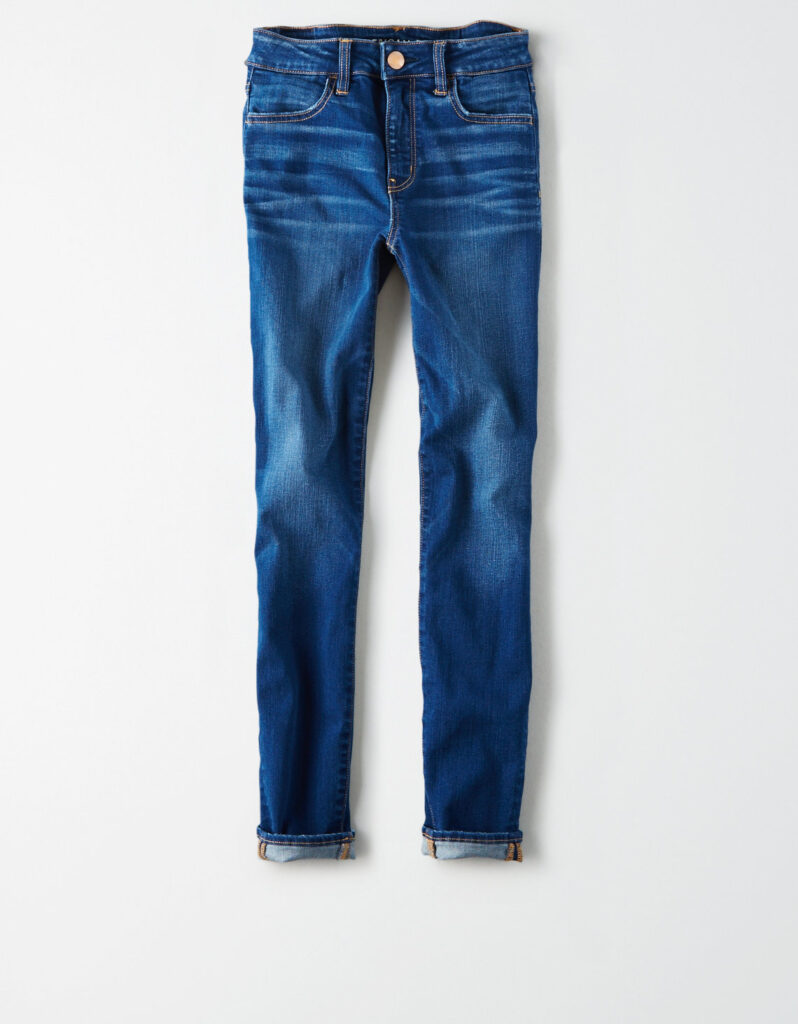 Denim pants folded at the legs in front of a white background