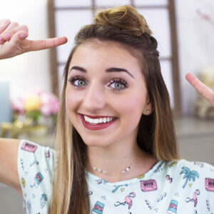 Portrait of young girl smiling and pointing at her head modeling "Triple Top Knot" hairstyle