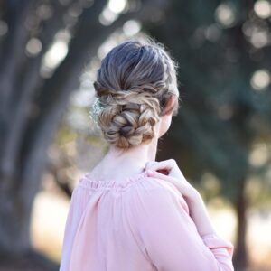 Back view of girl wearing a pink shirt standing outside modeling "Dutch Braided Updo" hairstyle