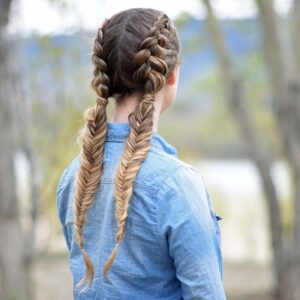 Back view of girl wearing a blue shirt standing outside modeling "Double Dutch Fishtails" hairstyle