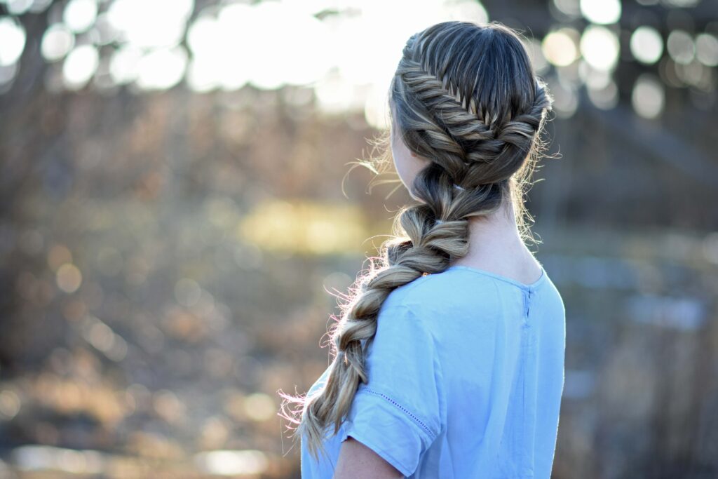 Side view of young girl with long hair modeling "Side Pull Thru Combo" hairstyle