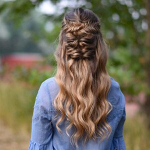 Back view of young girl wearing a blue shirt standing outside modeling "Twisted Fishtail" hairstyle