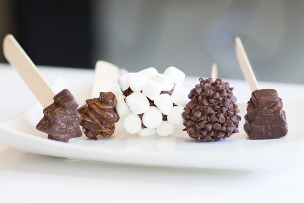5 Chocolate popsicles of assortment laying on a white plate. 