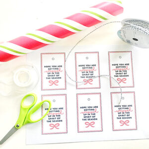 Assorted craft laying on a white background with printable "Hope you are getting wrapped up in the spirit of the season" tags