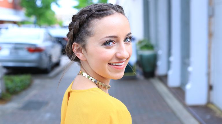 Side profile of girl smiling standing outside modeling a Double Dutch Buns