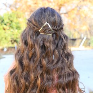 Back view of a young girl outside with long hair modeling "Barrette Tieback" hairstyle