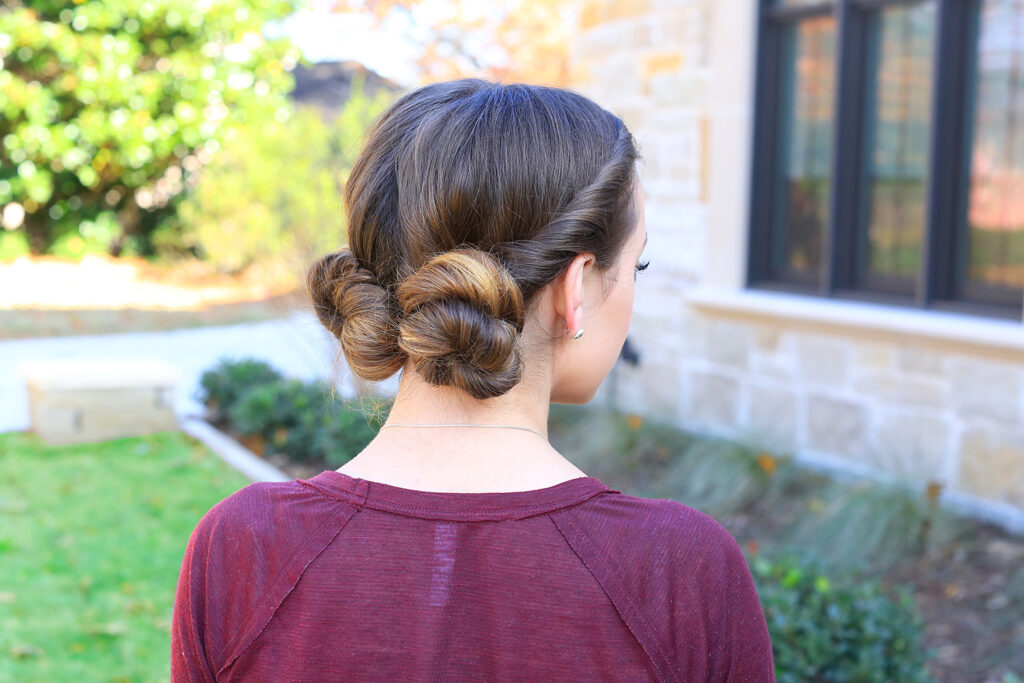 Back view of young girl standing outside modeling "Twist Back Buns" hairstyle