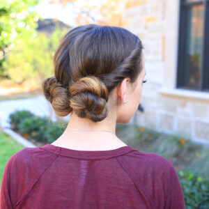 Side view of girl with burgundy shirt outside modeling "Twist Back Buns" hairstyle