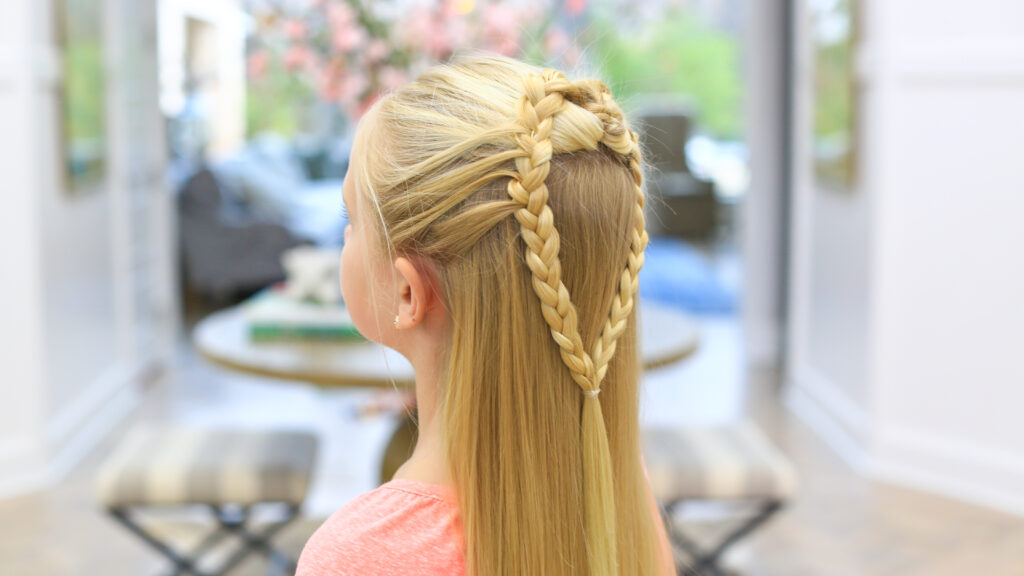 Side view of a girl with long blonde hair standing indoors modeling the "Mermaid Hair Braid" hairstyle