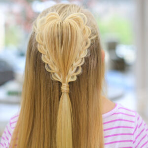 back view of a girl with long blonde hair standing indoors modeling the "Fluffy Heart Braid" hairstyle