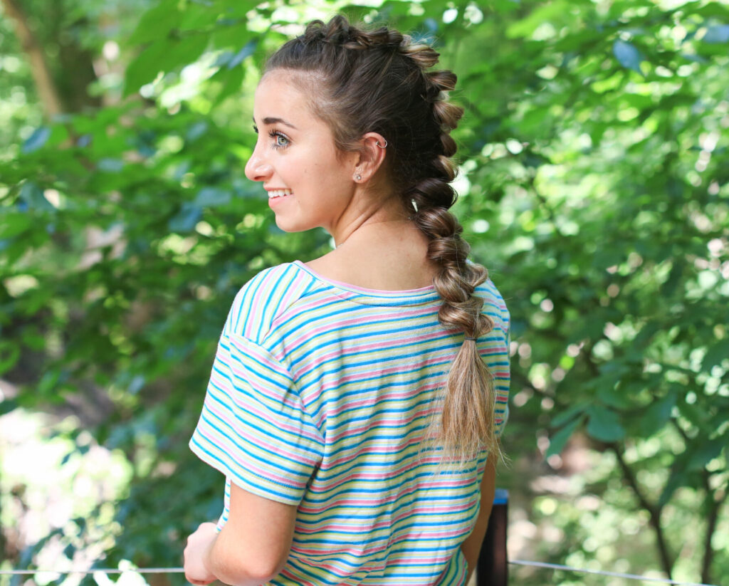 Side profile view of girl with striped shirt standing outside modeling the "CGH Wrap Braid" hairstyle