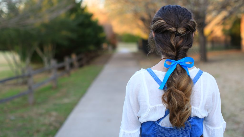 Back view of young girl with long in Halloween costume modeling "Belle Ponytail" hairstyle