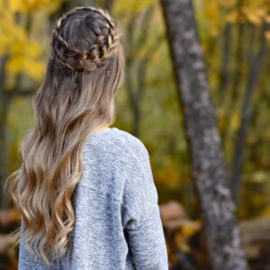 Back view of young woman outside wearing gray shirt, modeling "Dutch Halo Braid" hairstyle