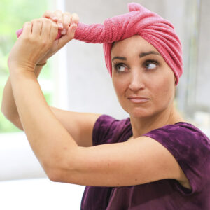 A woman twisting a towel to dry her hair