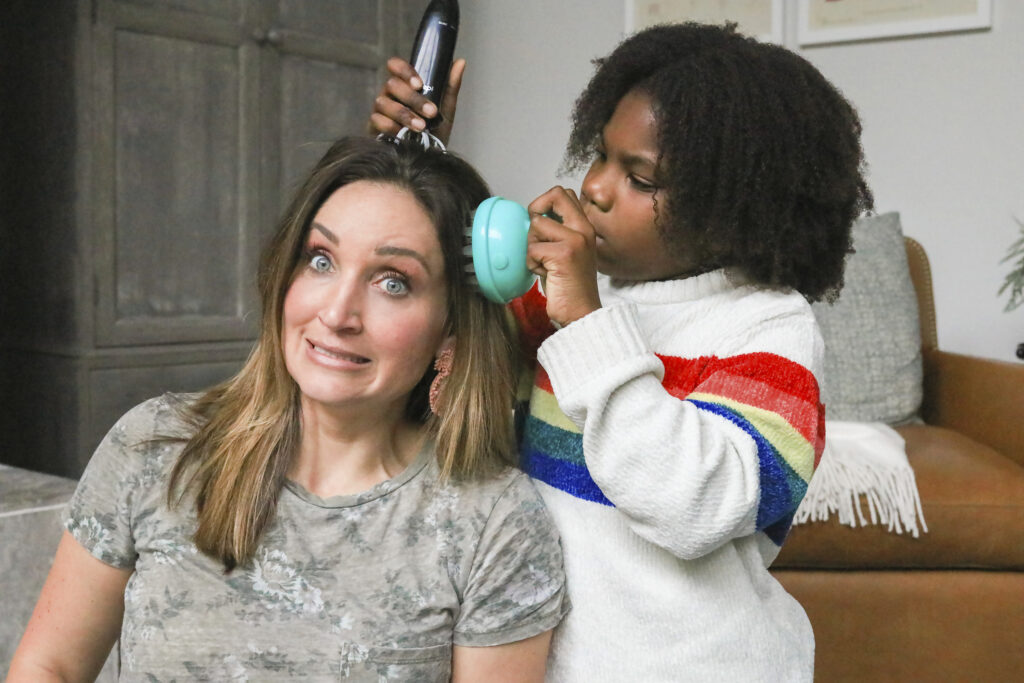 Mother and daughter are testing multiple head massagers on the mother's head.