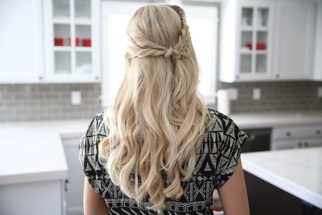 Back view of a blonde woman standing her kitchen modeling "Half Up Side Braid" hairstyle