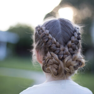 Back view of a young girl standing outside modeling "Flip Over Braid" hairstyle