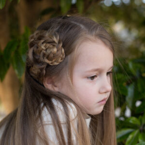 Profile of a young girl with long hair sitting outside