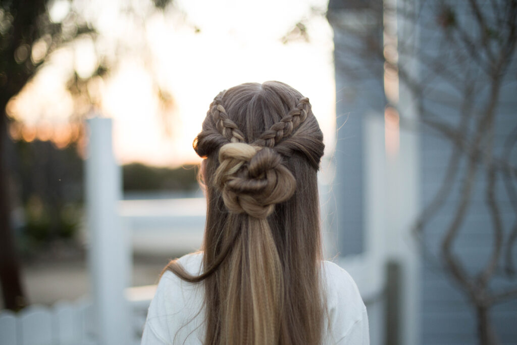 Close up back view of a young girl outside modeling cute "Braided Bun Combo" hairstyle