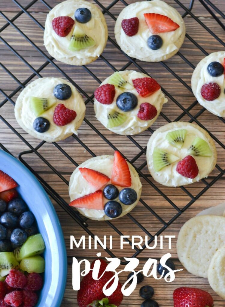 Mini Fruit Pizza cookies topped with an assortment of fruits placed on a cooling sheet