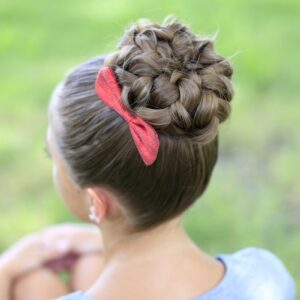 Young girl sitting outside modeling "Pancaked Bun of Braids" hairstyle