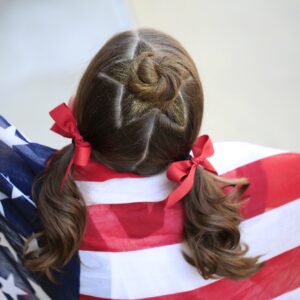 Little girl holding American flag modeling Star Bun Combo | 4th of July Hairstyles