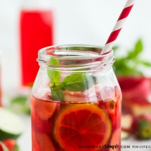 Sangria on a wooden table surrounded by strawberries