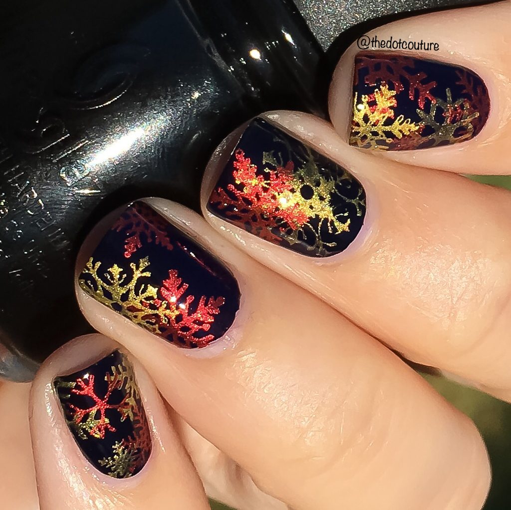 Black holiday nails with red and gold snowflakes nail art