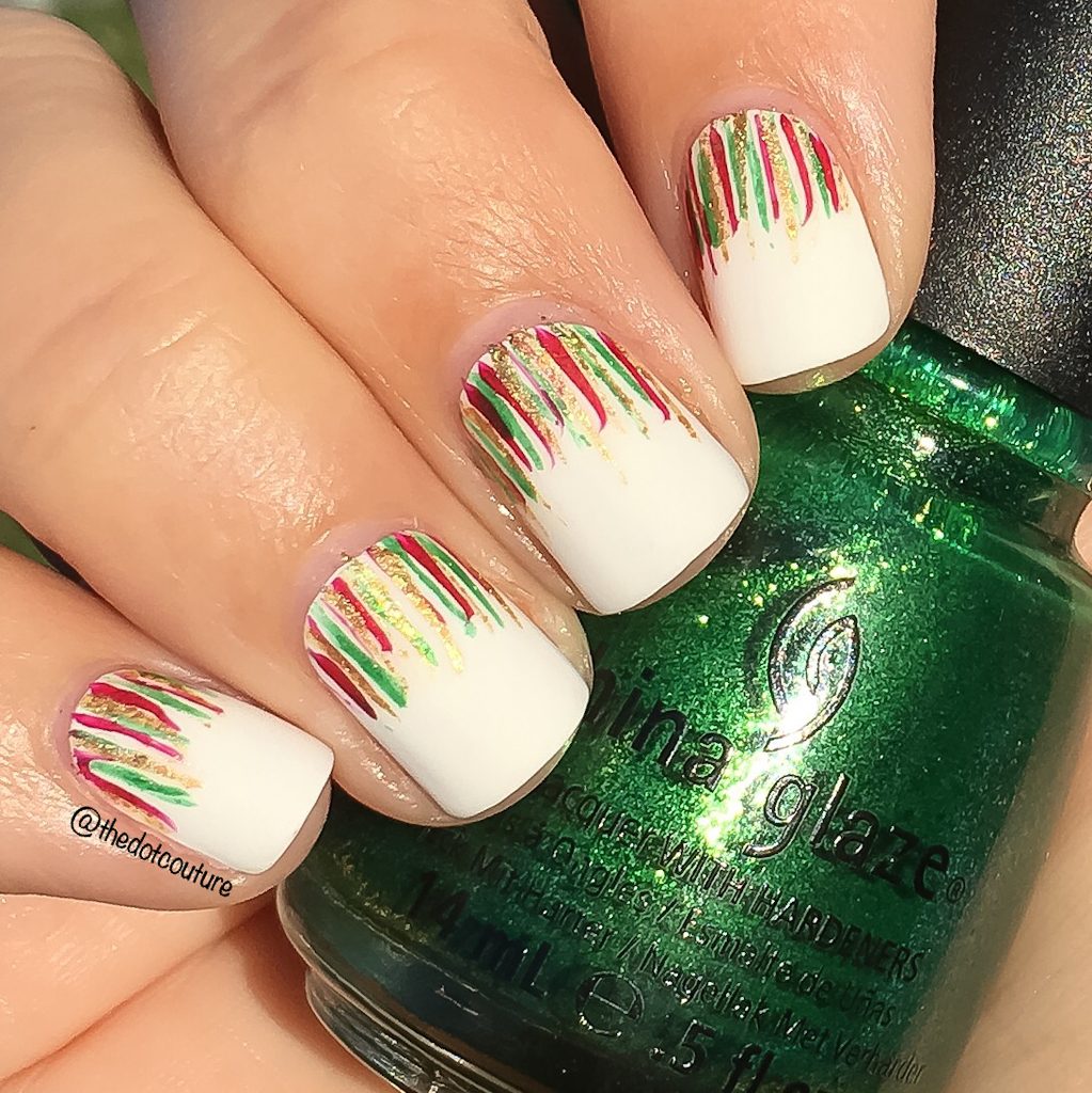 Holiday white painted nails with red, green, and gold streaks