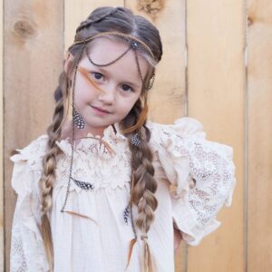 Girl with hands on her hips outside wearing a boho-inspired headband modeling "Boho Side Braids" hairstyle