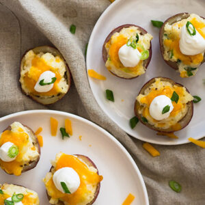 Twice Baked Potato Bites topped with sour cream and chives on a white plate