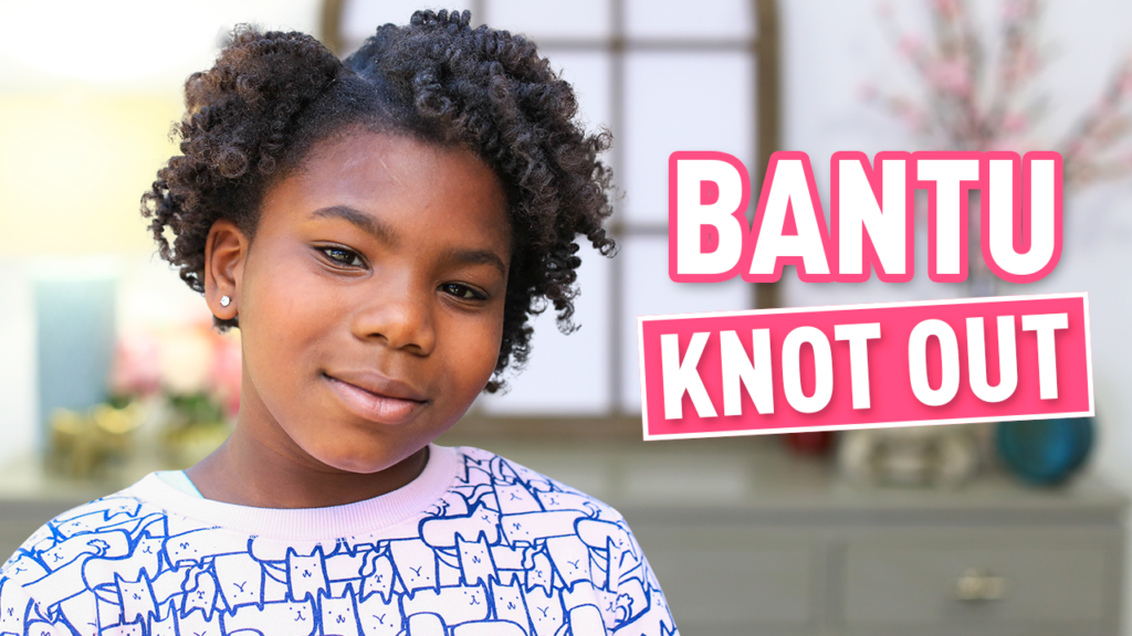 Young girl smiling at the camera "Bantu Knot Out"
